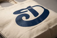 Silk screen printing displayed on canvas tote bag panel showing full logo coverage and ink texture