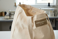 Woven label and inside tag branding displayed on canvas tote bag showing OEM label placement detail